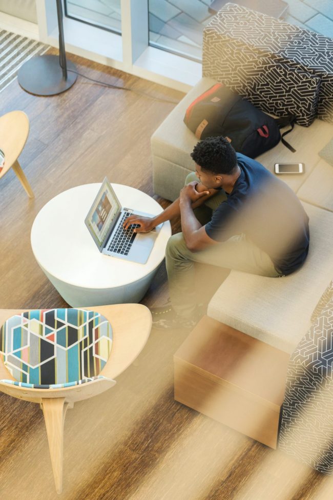 Man Using Gray Laptop While Sitting On Beige Sofa 1251862